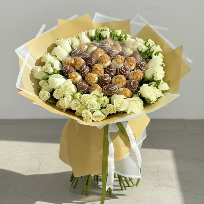 Luxurious bouquet of white roses and assorted chocolates wrapped in gold and tied with satin ribbon – elegant One Love floral and sweet gift in UAE.